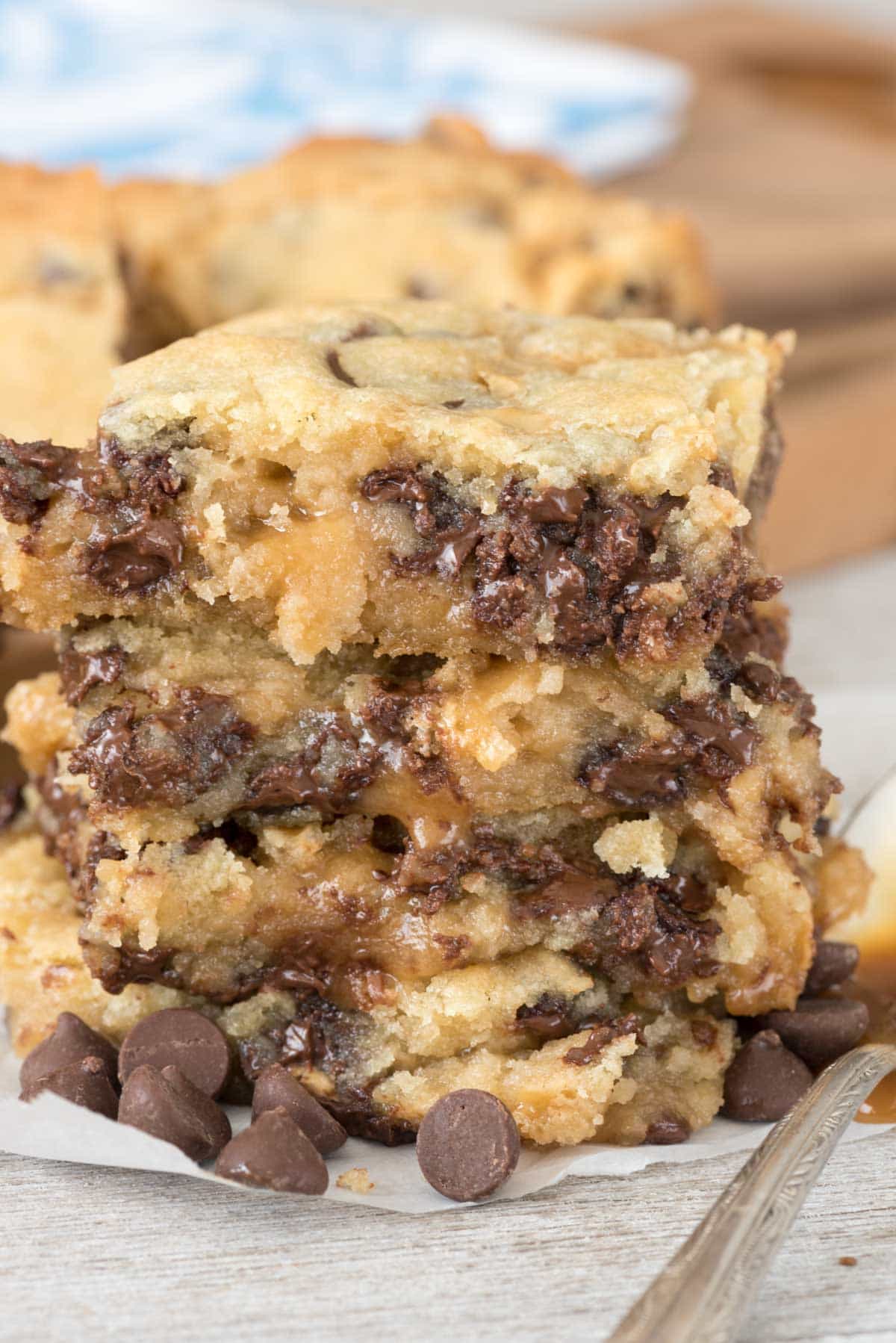 Barres au caramel et aux pépites de chocolat - des barres de biscuits au sucre faciles à réaliser, remplies de pépites de chocolat et prises en sandwich avec une sauce au caramel gluante ! Ces barres gluantes sont SI addictives.