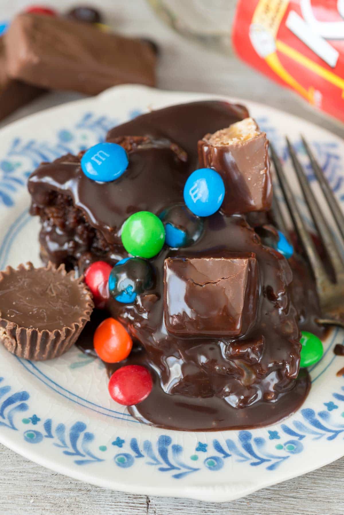 Gooey Candy Brownie Cake - this EASY brownie recipe is baked like a cake, FILLED with candy, and topped with a pourable chocolate frosting. It's chocolate heaven!