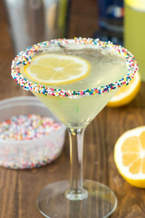 Lemon cupcake martini in a martini glass with sprinkles and lemon slices