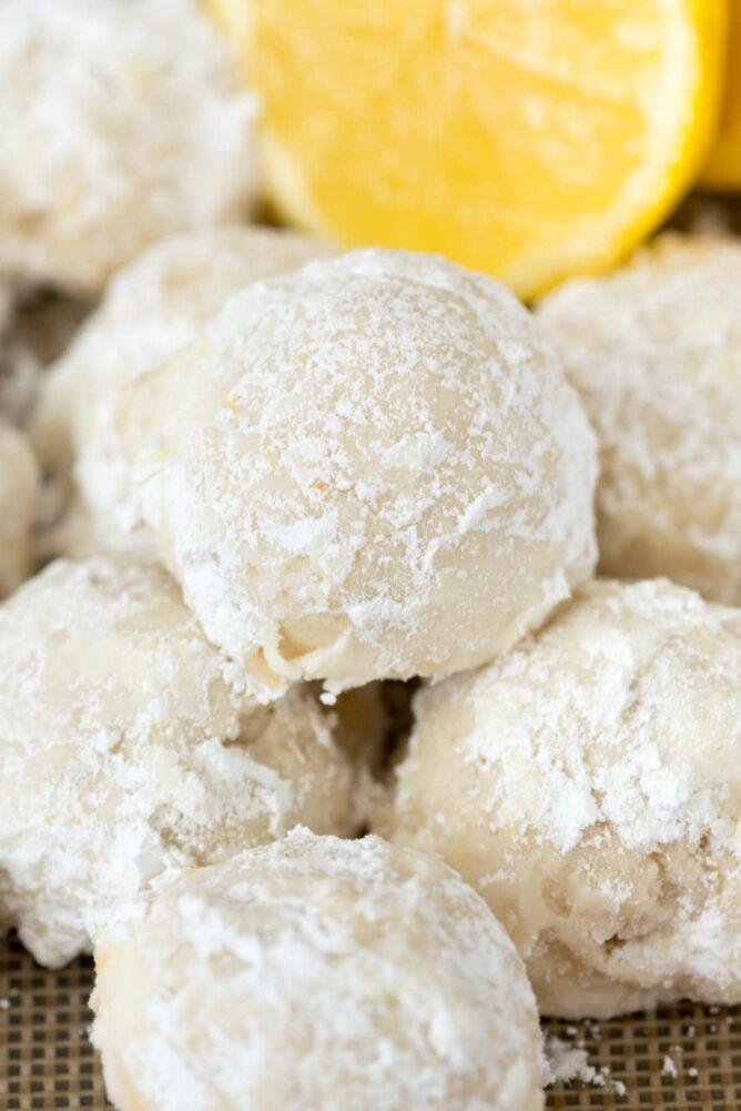 Buttery Lemon Snowball Cookies with a lemon in the background