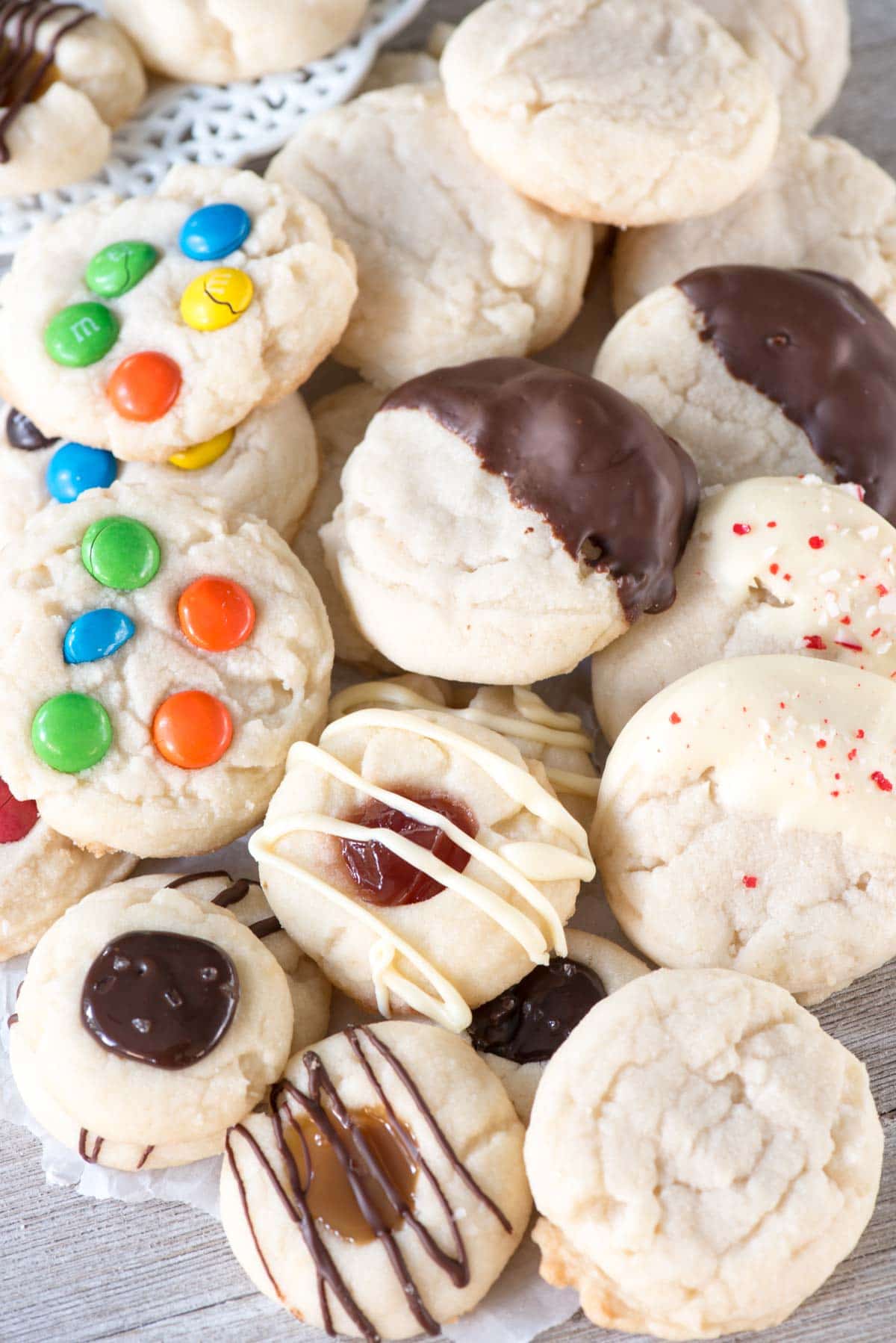 Soft chewy shortbread cookies are made from one shortbread recipe, with 4 cookie recipe variations. Add M&Ms, dip them in chocolate, or make shortbread thumbprint cookies!