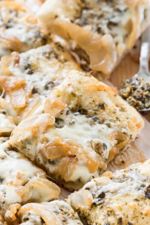 Caramelized Onion Pesto Flatbread Pizza slices on a cutting board