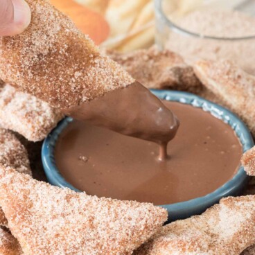Baked Churro Chips being dipped in Chocolate