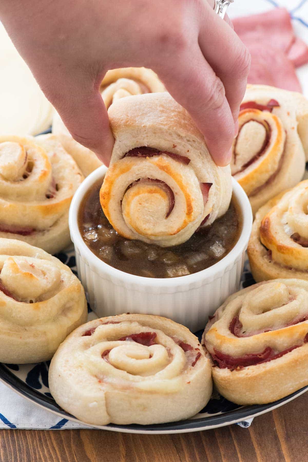 French Dip Pinwheels - this easy pinwheel recipe is perfect for an appetizer or dinner! Pizza dough is wrapped with roast beef and cheese and dipped in a french dip sauce!