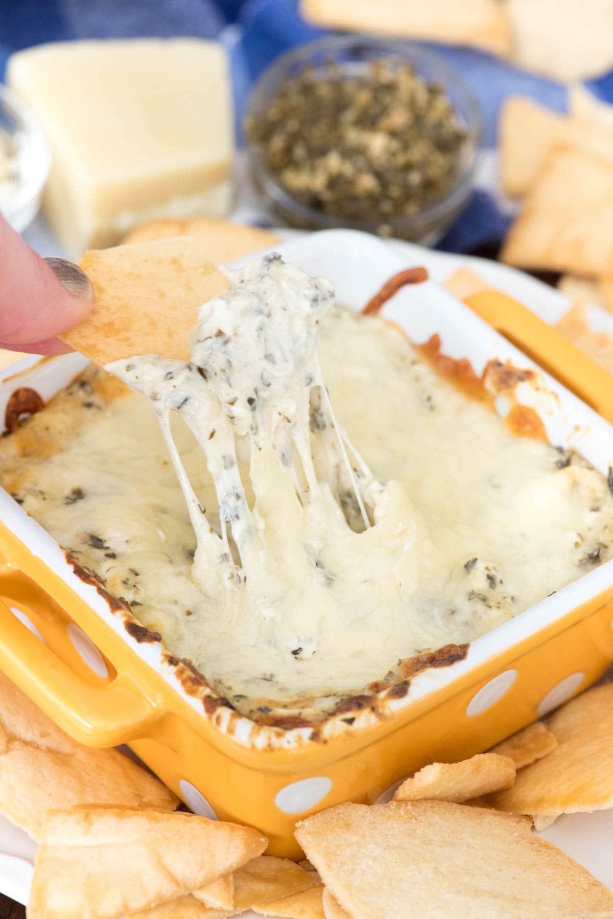 Hot Cheesy Pesto Dip - this super EASY appetizer is the perfect dip! Just 5 ingredients make a gooey cheesy dip full of basil and garlic pesto flavor!