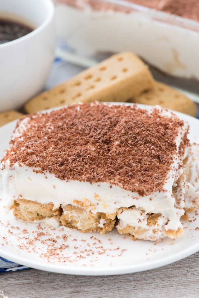 Biscuits sablés avec un dessert Tiramisu sur une petite assiette blanche.