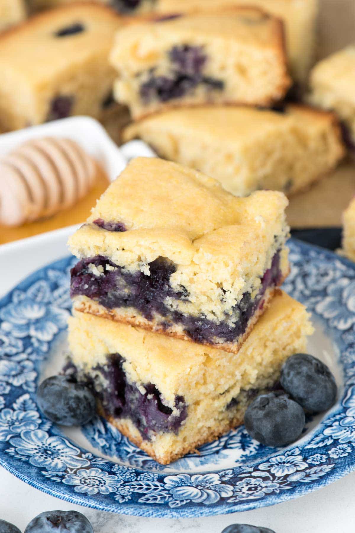 Blueberry Cornbread on a blue serving plate with blueberries on the side.