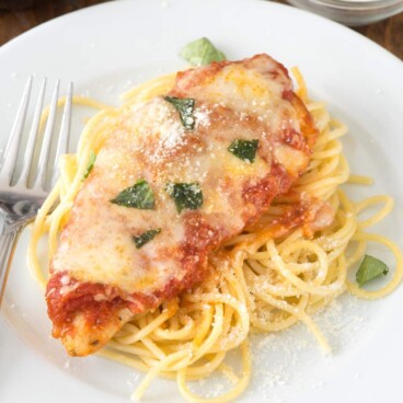 Easy Chicken Parmesan with pasta on a white plate with a fork
