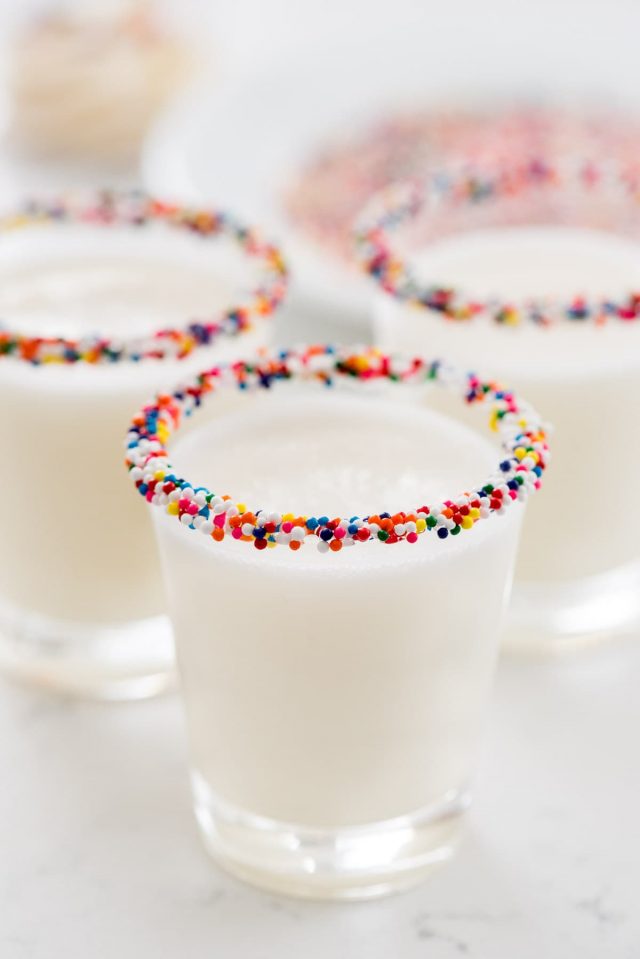 Three frosting Shots rimmed with colorful sprinkles.