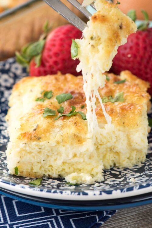 Cheesy Egg Casserole on a blue and white plate and a bit on a fork