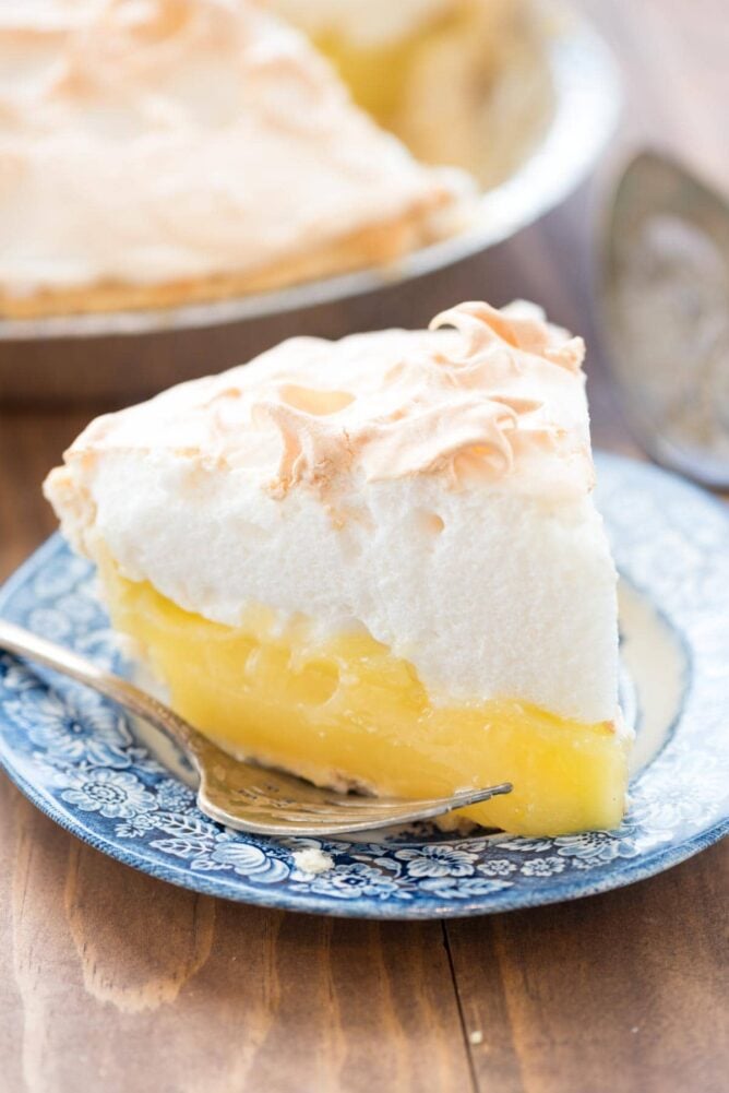 Aunt Tootsie's Lemon Meringue Pie on a blue plate with a fork.