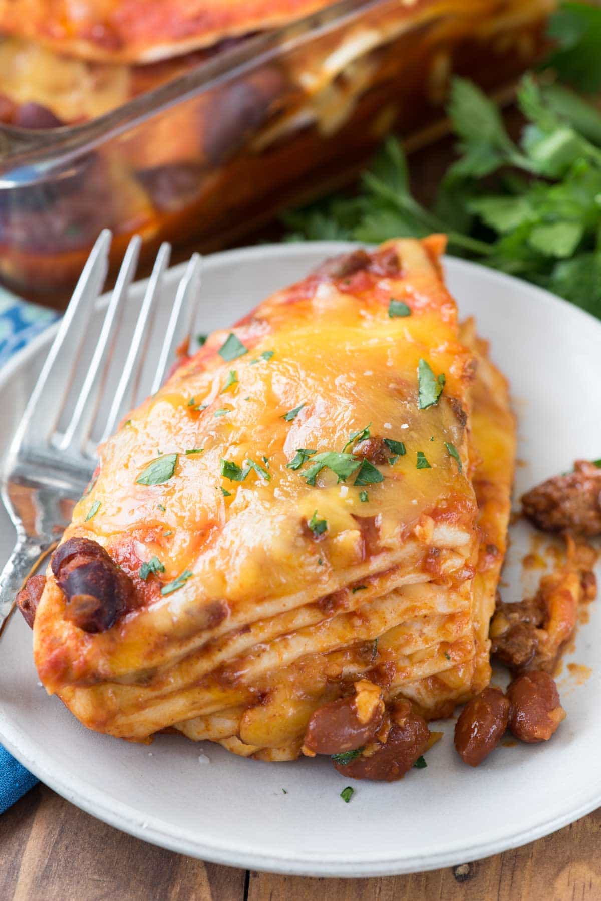 Slice of Bean Stuff Casserole on a white plate with a fork