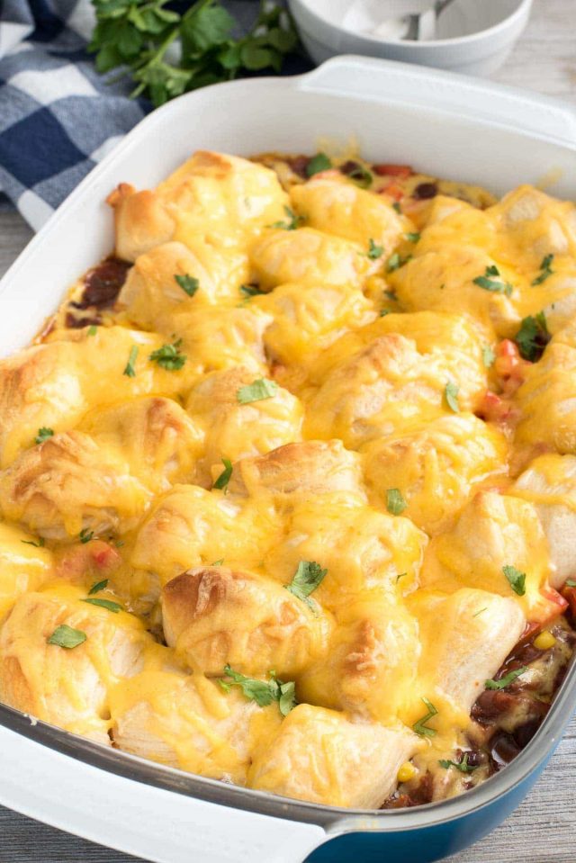 Cheesy Chili Bake in a blue casserole dis on a wooden table. 