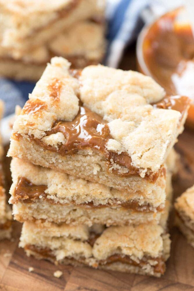 Stack of Dulce de Leche Gooey Butter Bars on a wood table