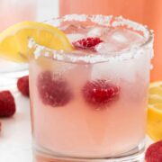 Raspberry Lemonade Margarita on a white counter - this EASY cocktail recipe is the perfect margarita! Raspberry Lemonade, tequila, and triple sec- that's all it takes to make a pitcher!