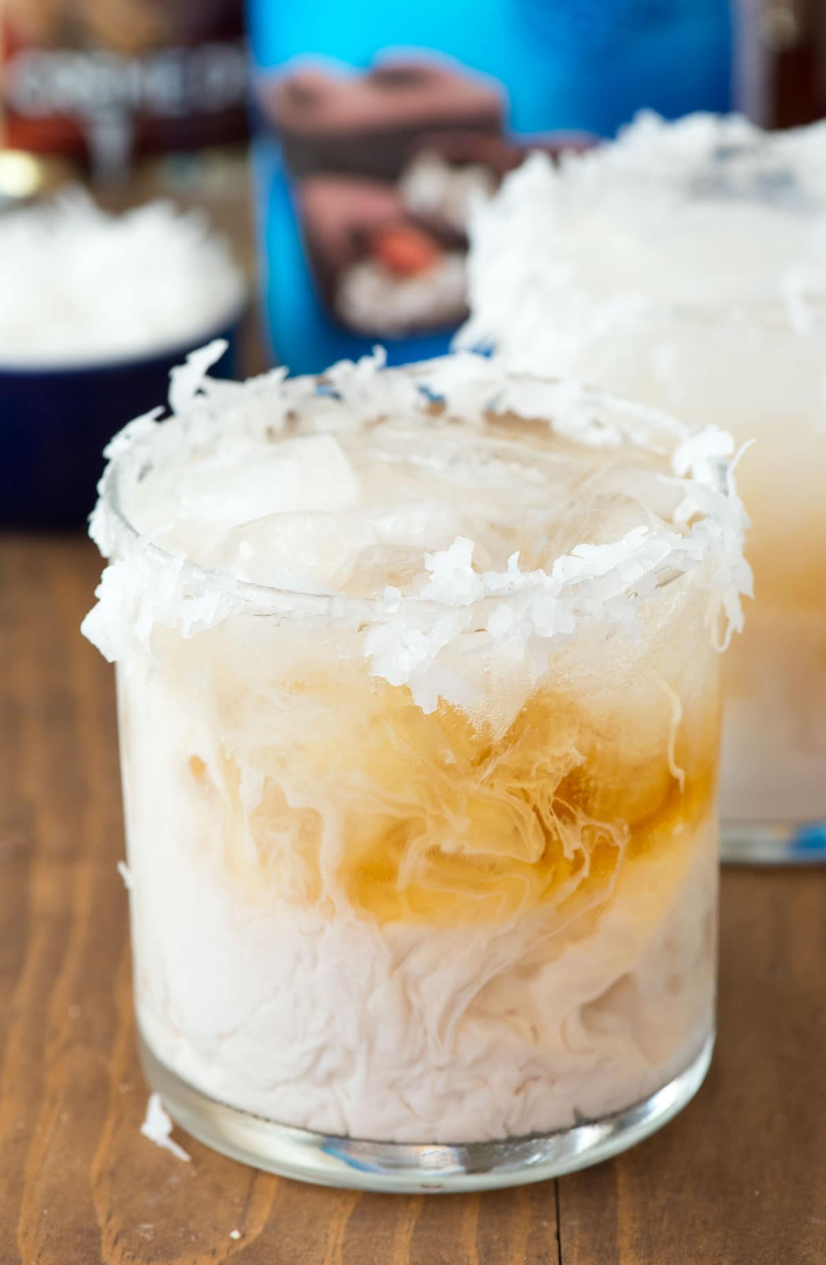 Almond Joy Cocktail rimmed with coconut shavings on a wooden table. 