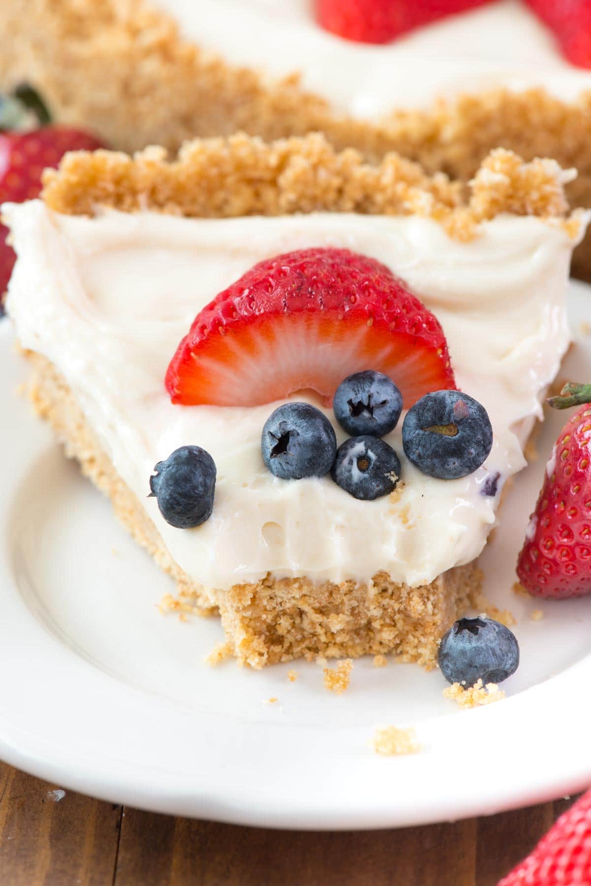 A bite taken out of the BEST No Bake Cheesecake Recipe on a white serving plate. 