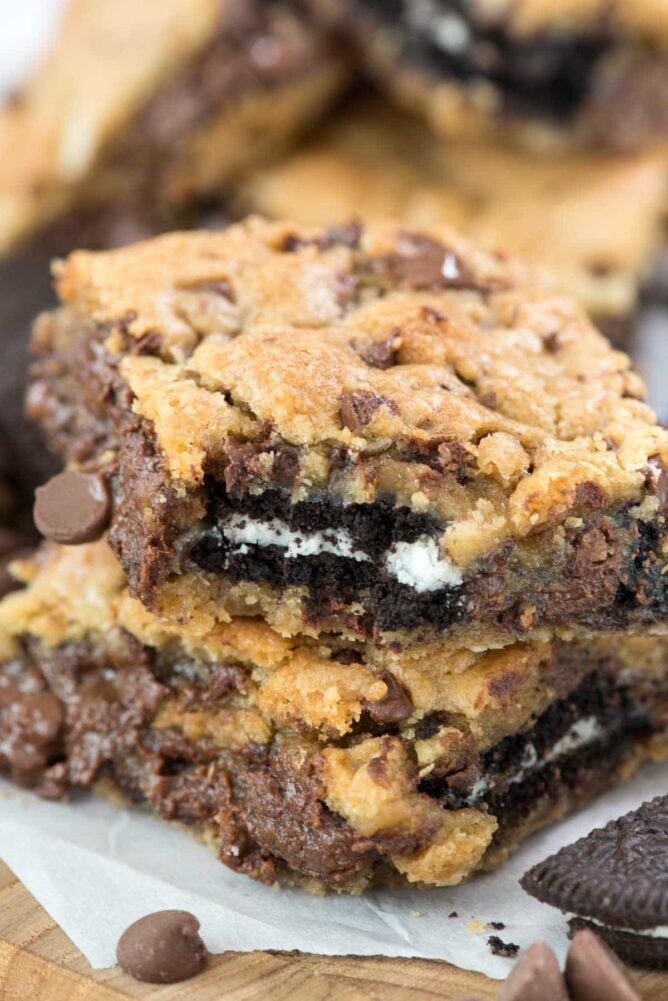 Oreo Stuffed Chocolate Chip Cookie Gooey Bars in a stack with bite missing