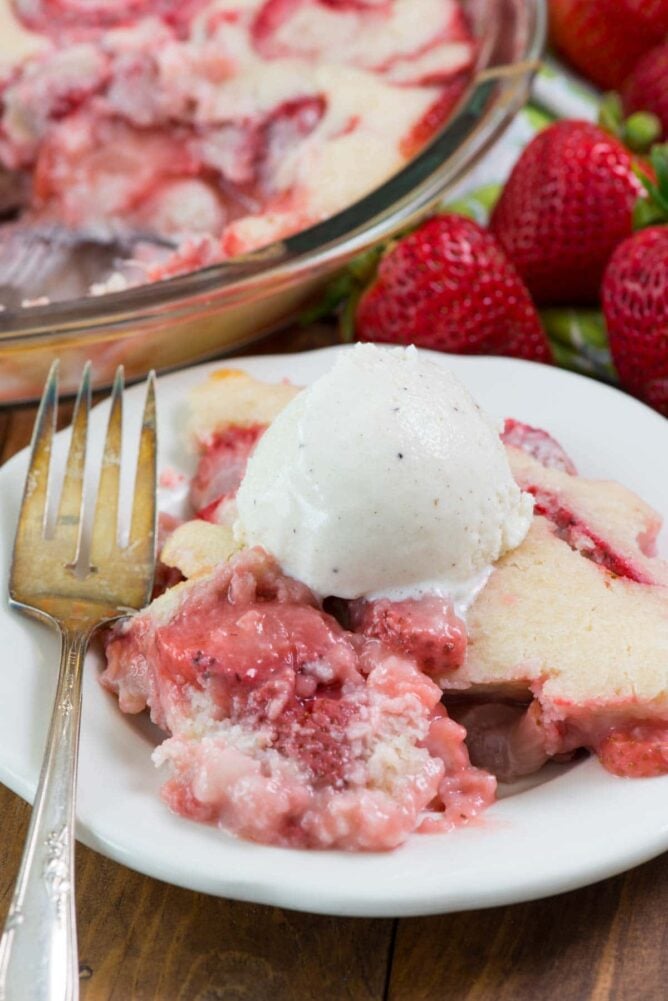 Easy Strawberry Cobbler on white plate with ice cream on top and fork
