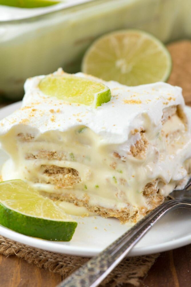 No Bake Key Lime Eclair on a white plate with fork and slices of lime