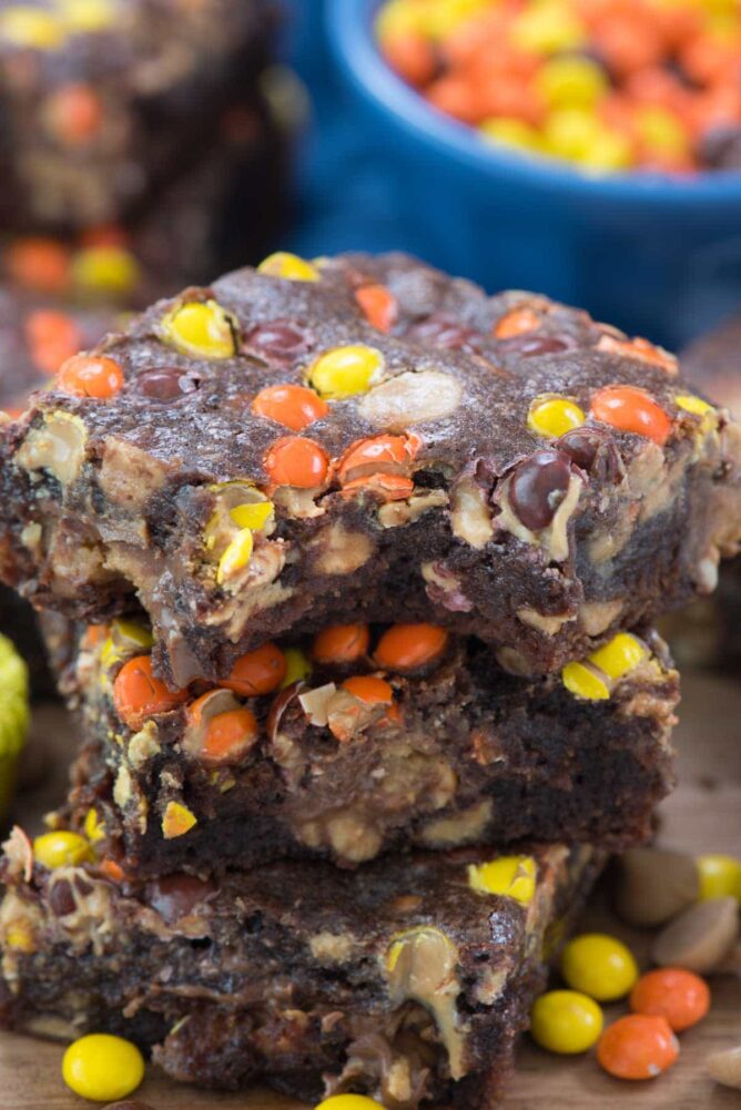 The ULTIMATE One Bowl Reese's Brownie Recipe in a stack with bite missing