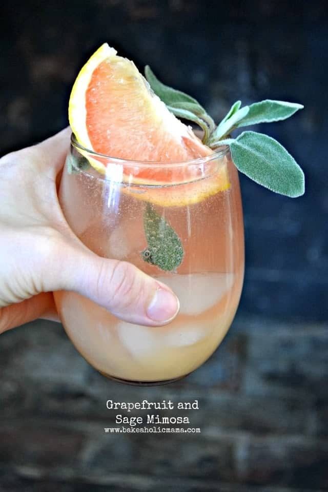 One glass of Grapefruit and Sage Mimosa garnished with sliced grapefruit. 