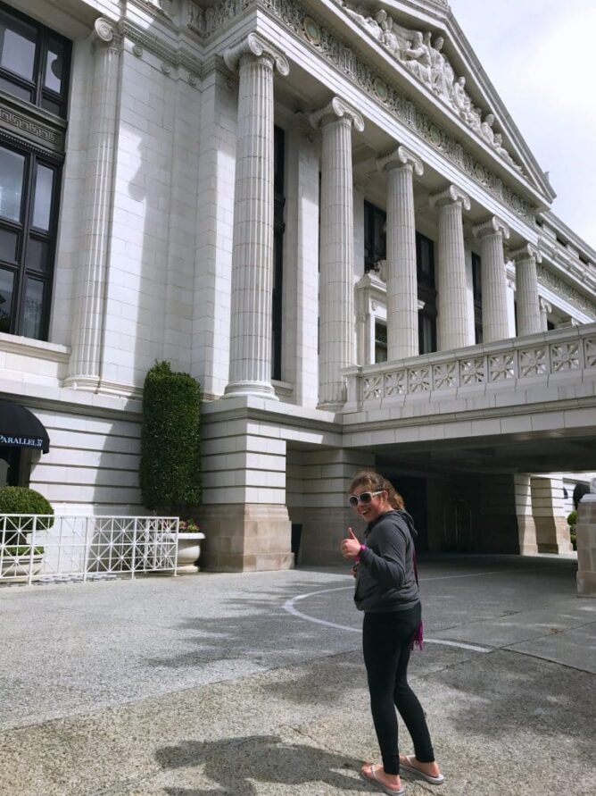 girl giving thumbs up in front of the ritz carlton hotel