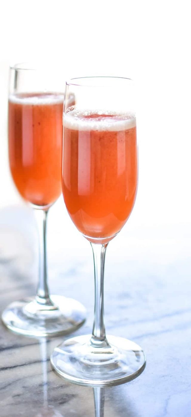 Two glasses of Strawberry Beermosas on a table. 