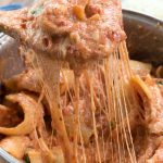 close up of One Pot Stuffed Shells with a spoonful being taken out of the pot for serving