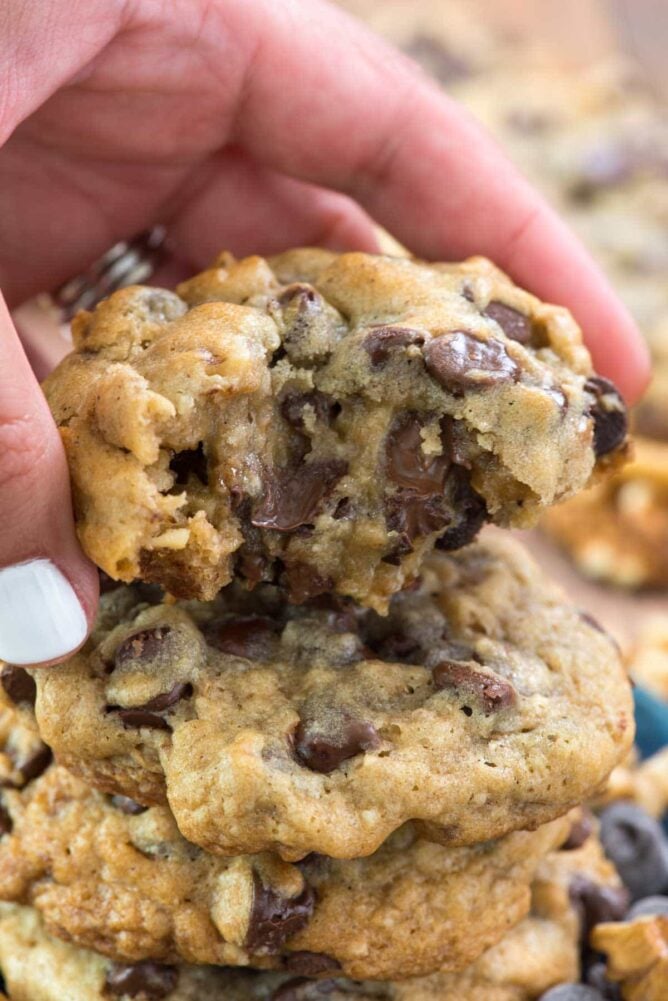 Stack of Copycat Doubletree Chocolate Chip Cookies and one being held by a person