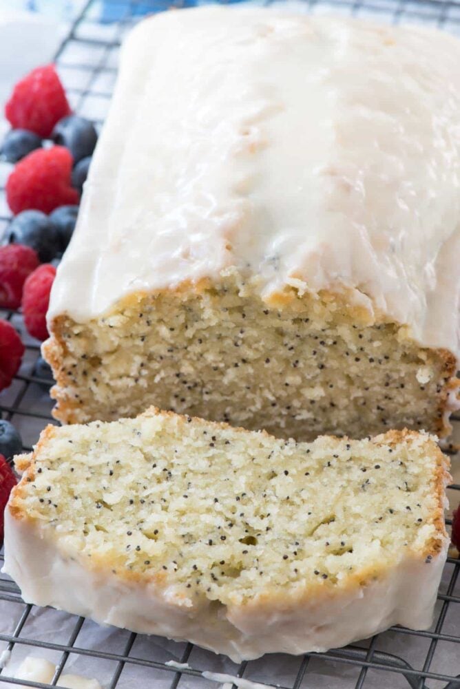 Almond Poppyseed Loaf Cake on rack with one slice