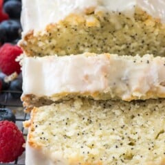 sliced almond poppyseed cake with frosting on rack
