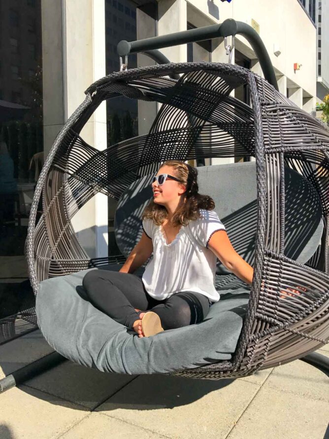 girl sitting in big round chair