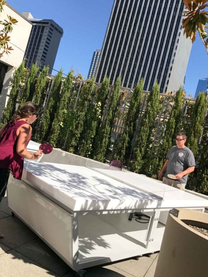 father and daughter playing ping pong on patio