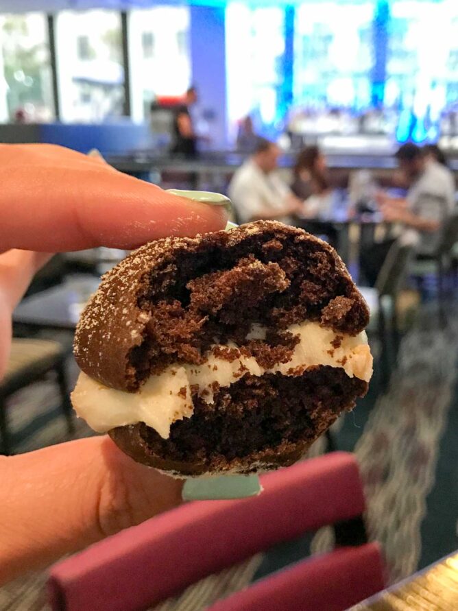 Frolik Kitchen and Cocktails dessert cookie sandwich being held with bite missing