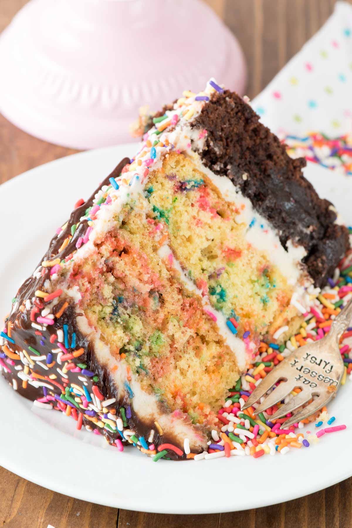 Funfetti Brownie Layer Cake - this cake is easier than it looks! There's a layer of brownie and two layers of confetti cake, filled with a cream cheese frosting and topped with a hot fudge chocolate drizzle!