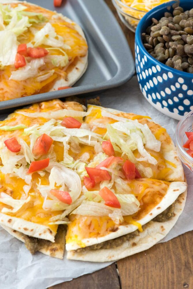 Mexican pizza on parchment paper with another one on a cookie sheet