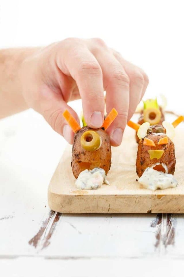 Vomiting Potato Monsters on a cutting board and person adding decorations