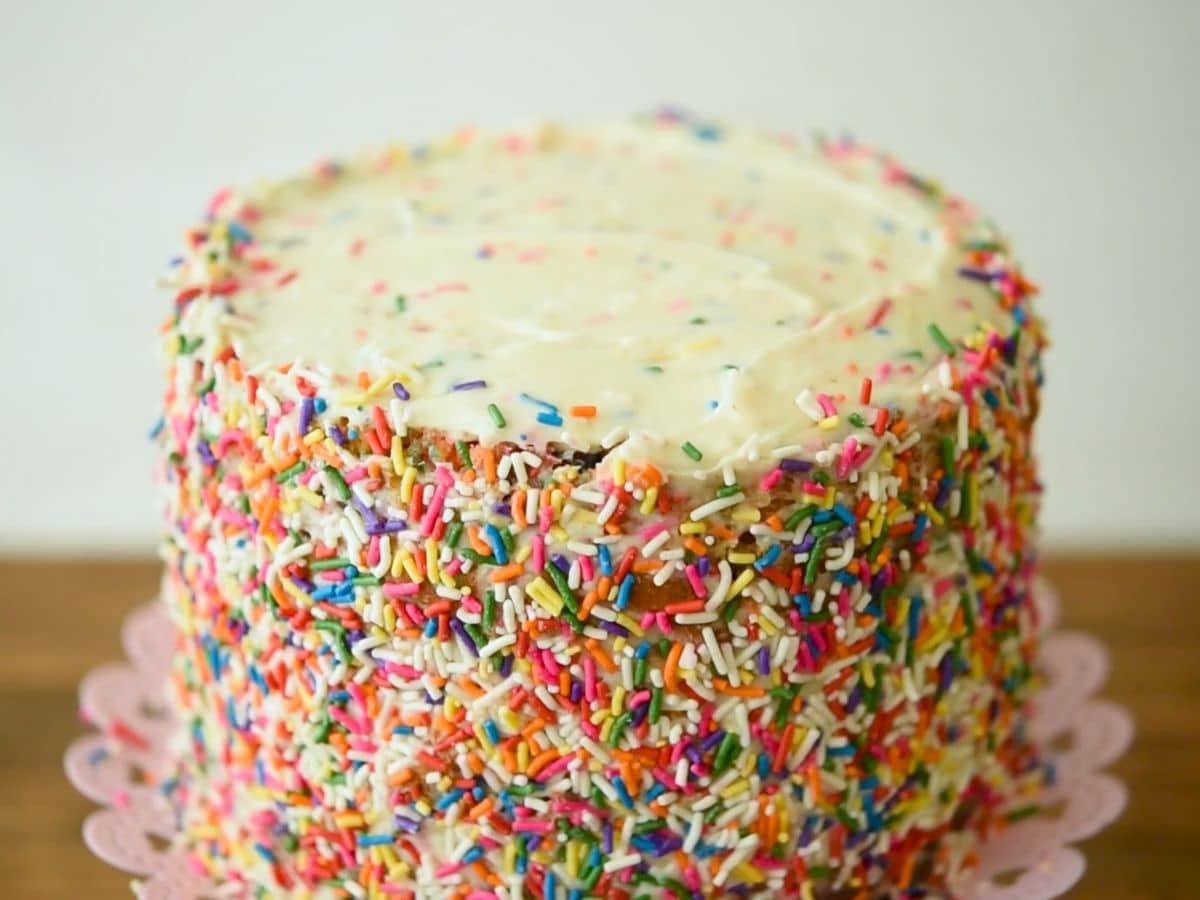 cake on cake plate with sprinkles around it.