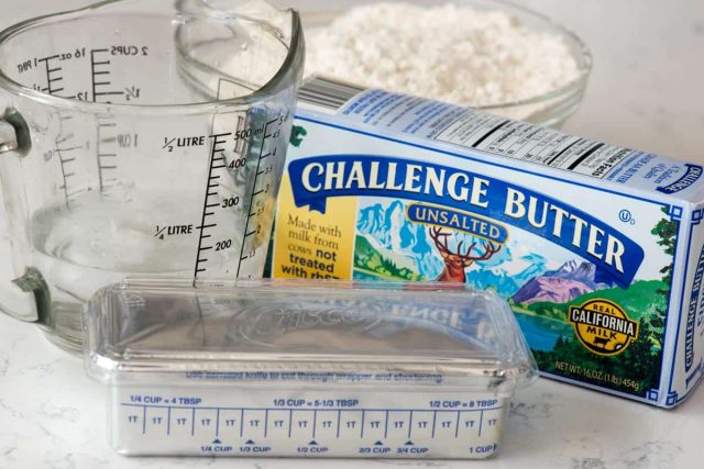 challenge butter box, a measuring cup and a stick of butter
