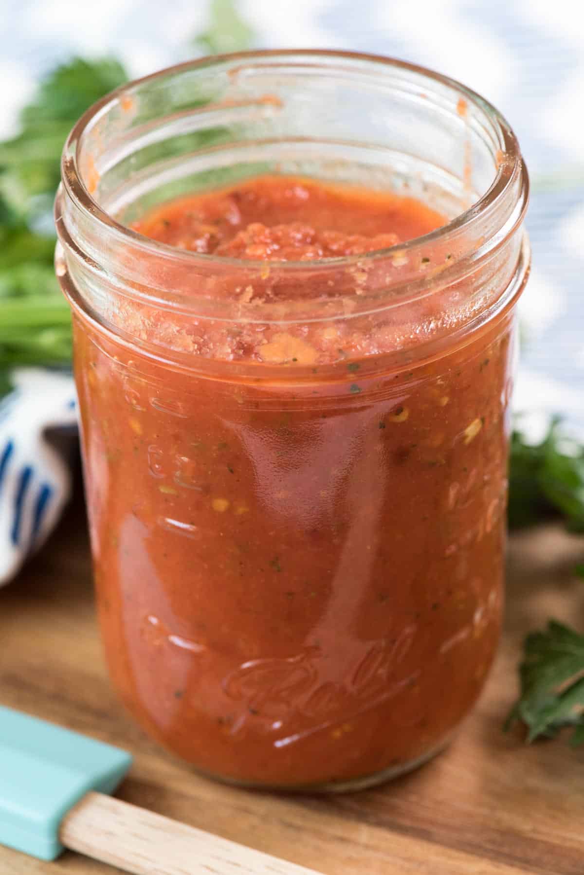 jar of pizza sauce on a cutting board