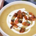 bowl of potato leek soup with sour cream, bacon, and thyme