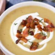bowl of potato leek soup with sour cream, bacon, and thyme