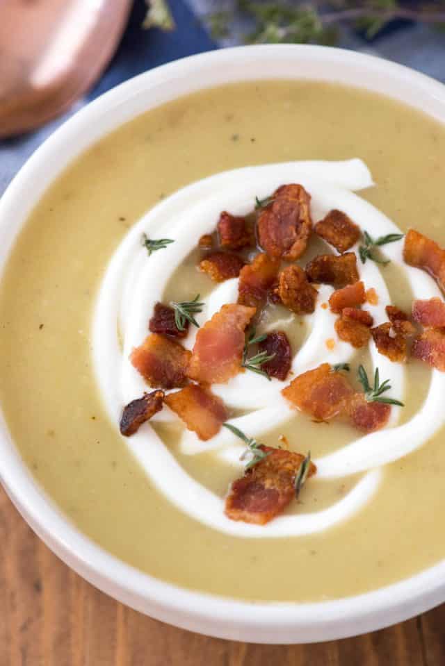 close up of bowl of soup with sour cream bacon and thyme