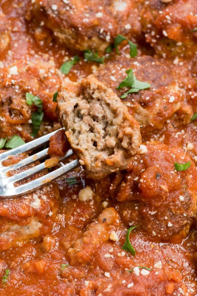 meatballs in sauce with half on a fork