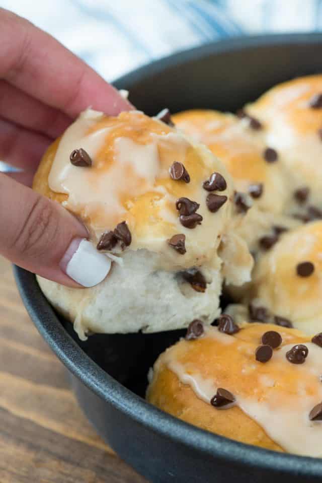 pan of biscuit bombs with hand picking up one