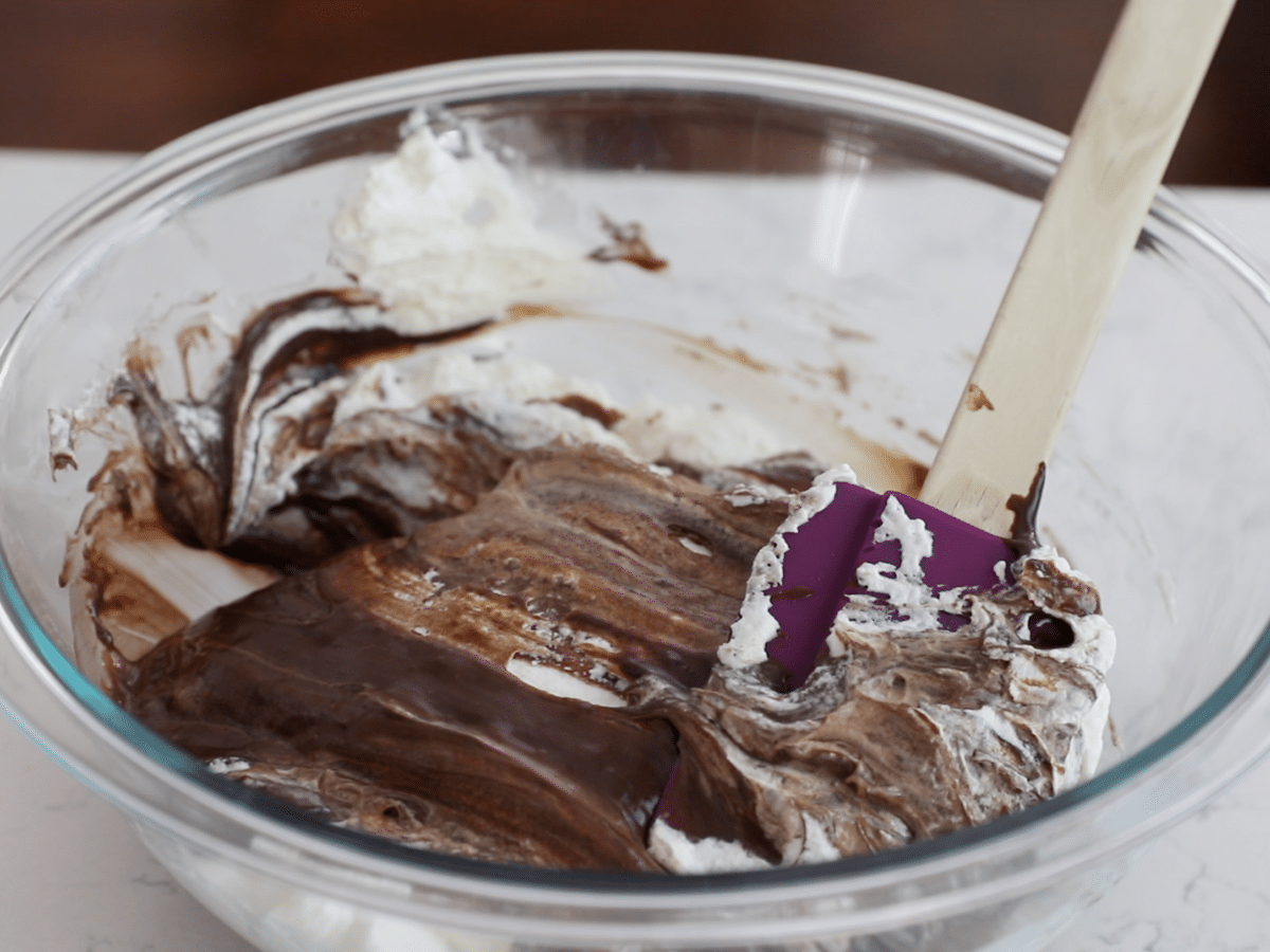 bowl of chocolate and whipped cream with spatula.