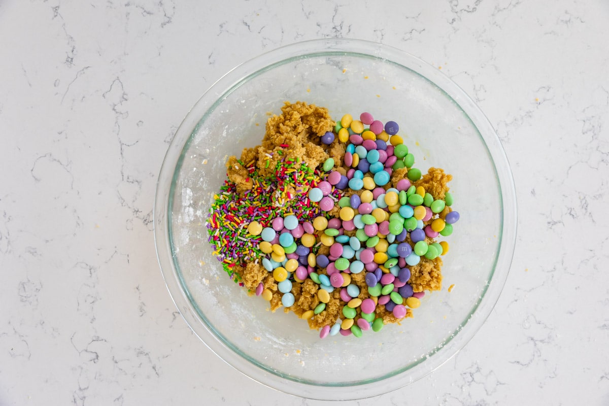 cookie dough in bowl with m&ms and sprinkles.
