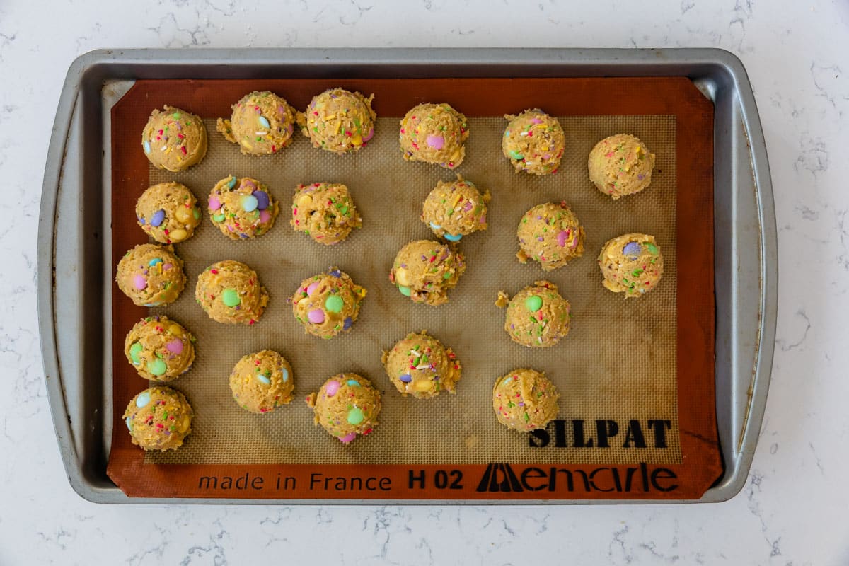 cookie dough balls on cookie sheet with silpat.