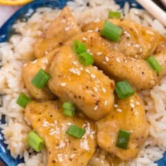orange chicken on a bed of rice on blue plate